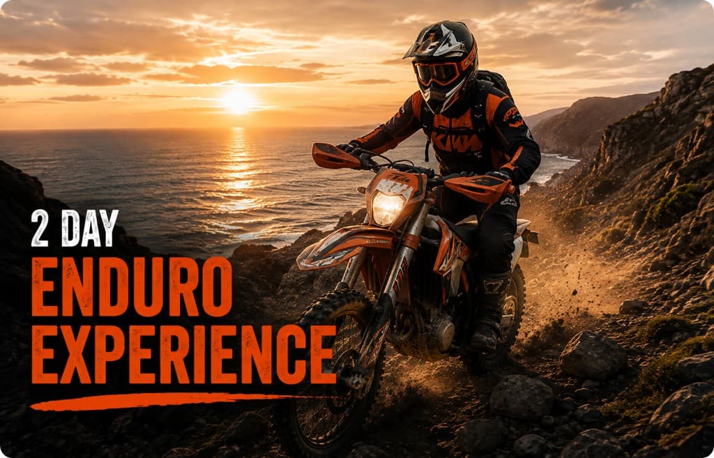 Enduro rider on a rocky cliffside trail at sunset over the ocean